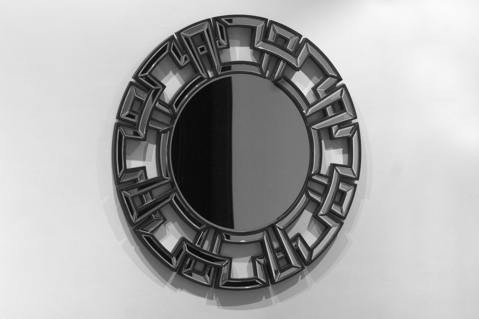Round wall mirror with a black frame