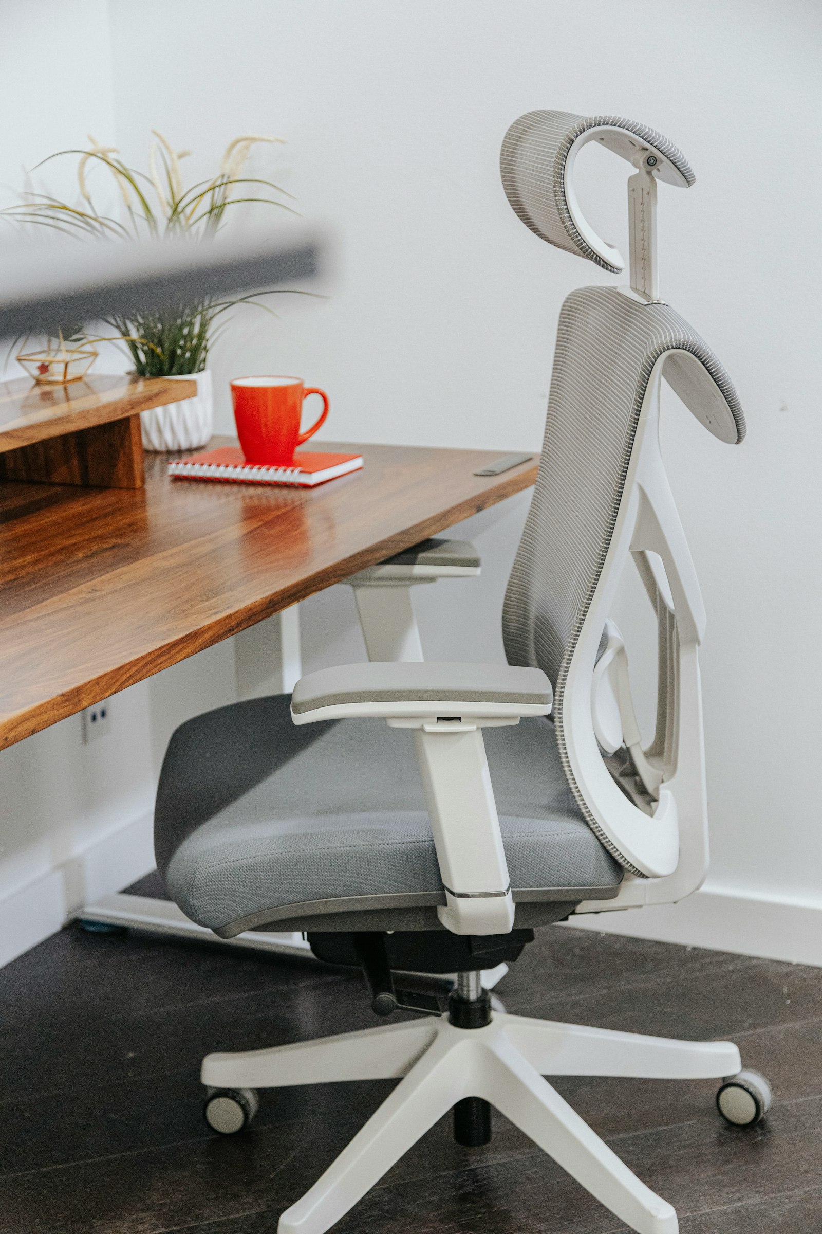 Gray ergonomic mesh office chair at a wooden desk